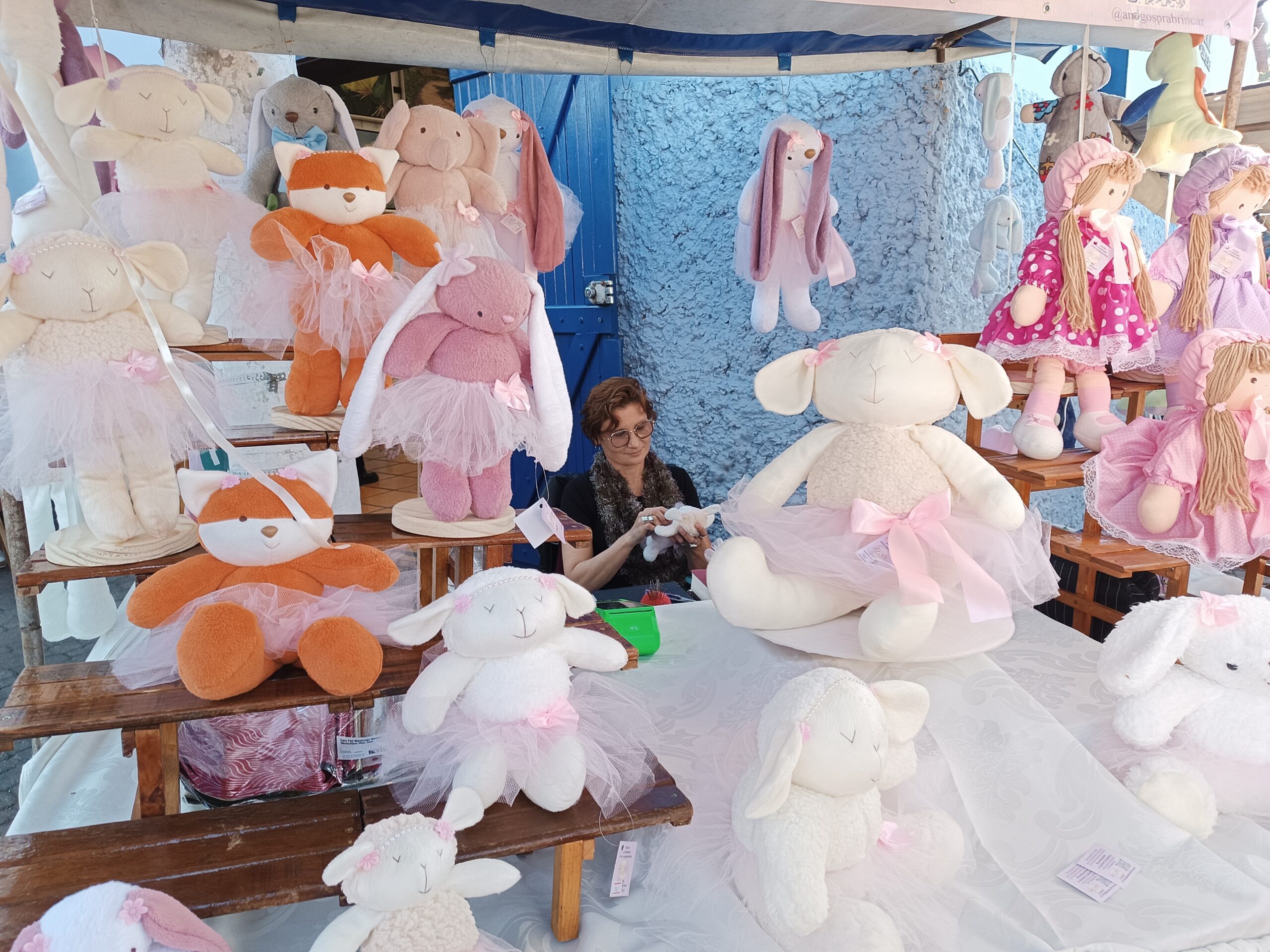 Elis em seu espaço de exposição na Feira, dando acabamento em uma peça.