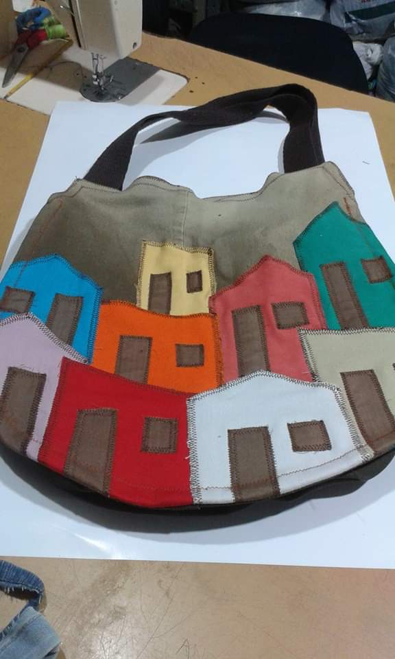 Bolsa customizada com casarios coloridos.