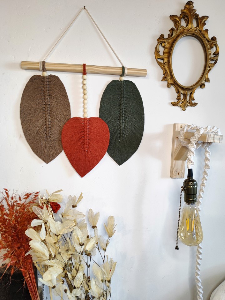 Peças decorativas em macramê, folhas coloridas e pendentes.