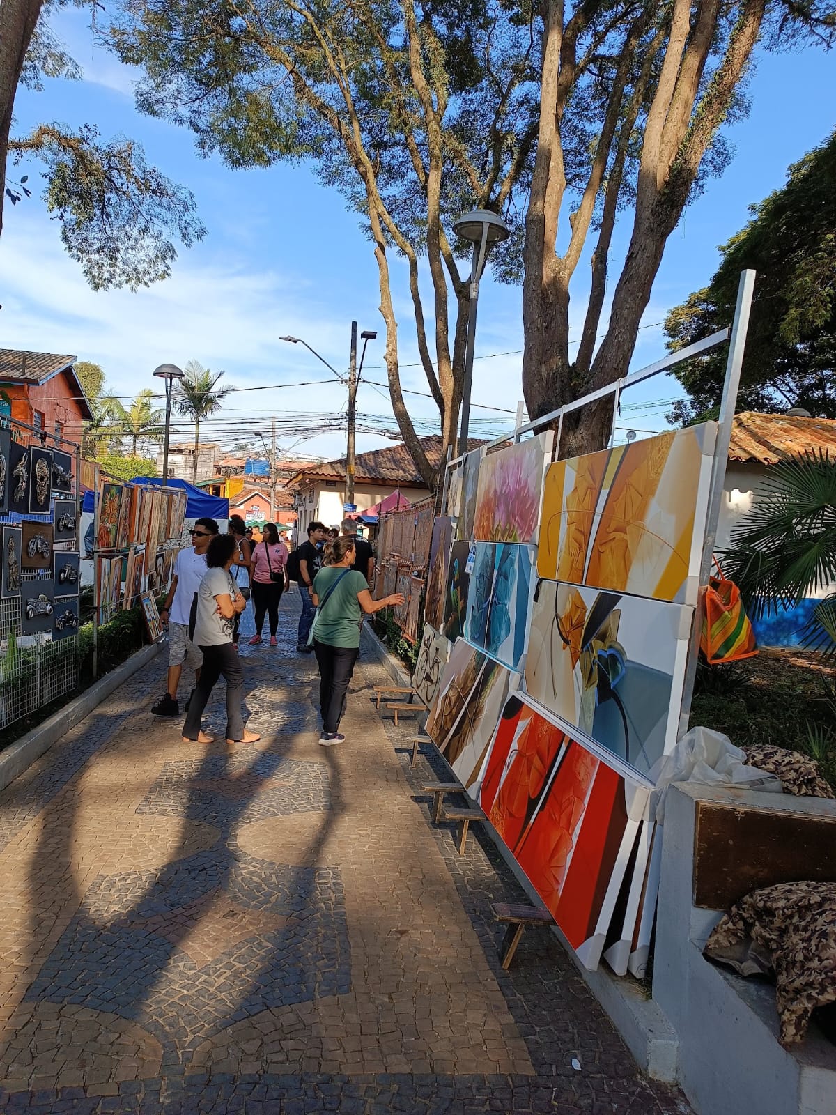 Turista passeia no corredor com exposição dos dois lados na Praças das Artes